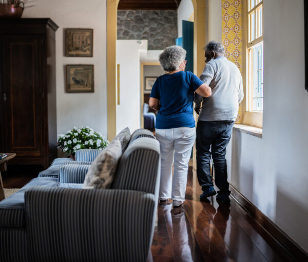 Wife helping husband walking at home